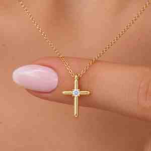Gold cross necklace with a small round diamond centered on the cross pendant