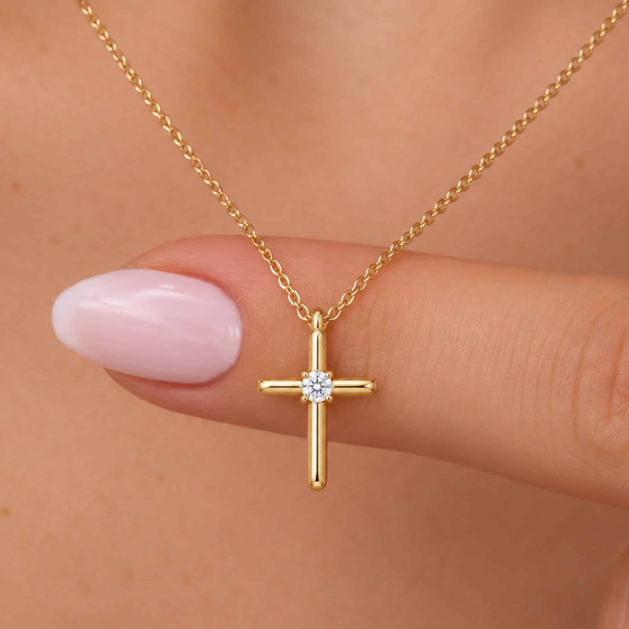 Gold cross necklace with a small round diamond centered on the cross pendant