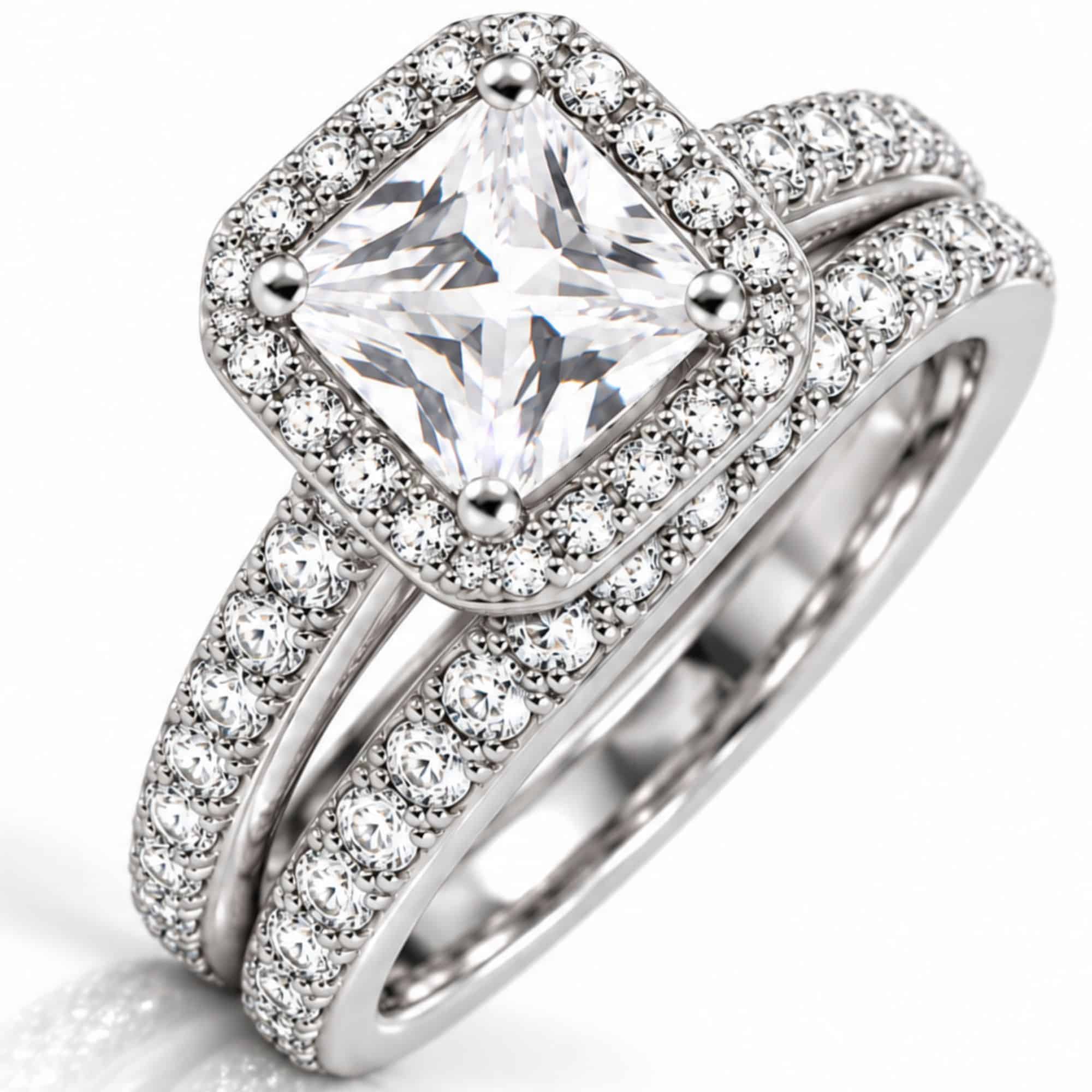 Silver-tone two-ring bridal set with square clear CZ center, halo accents and matching CZ wedding band.
