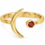 Gold-tone crescent moon ring with a small round red garnet set opposite the curved moon.