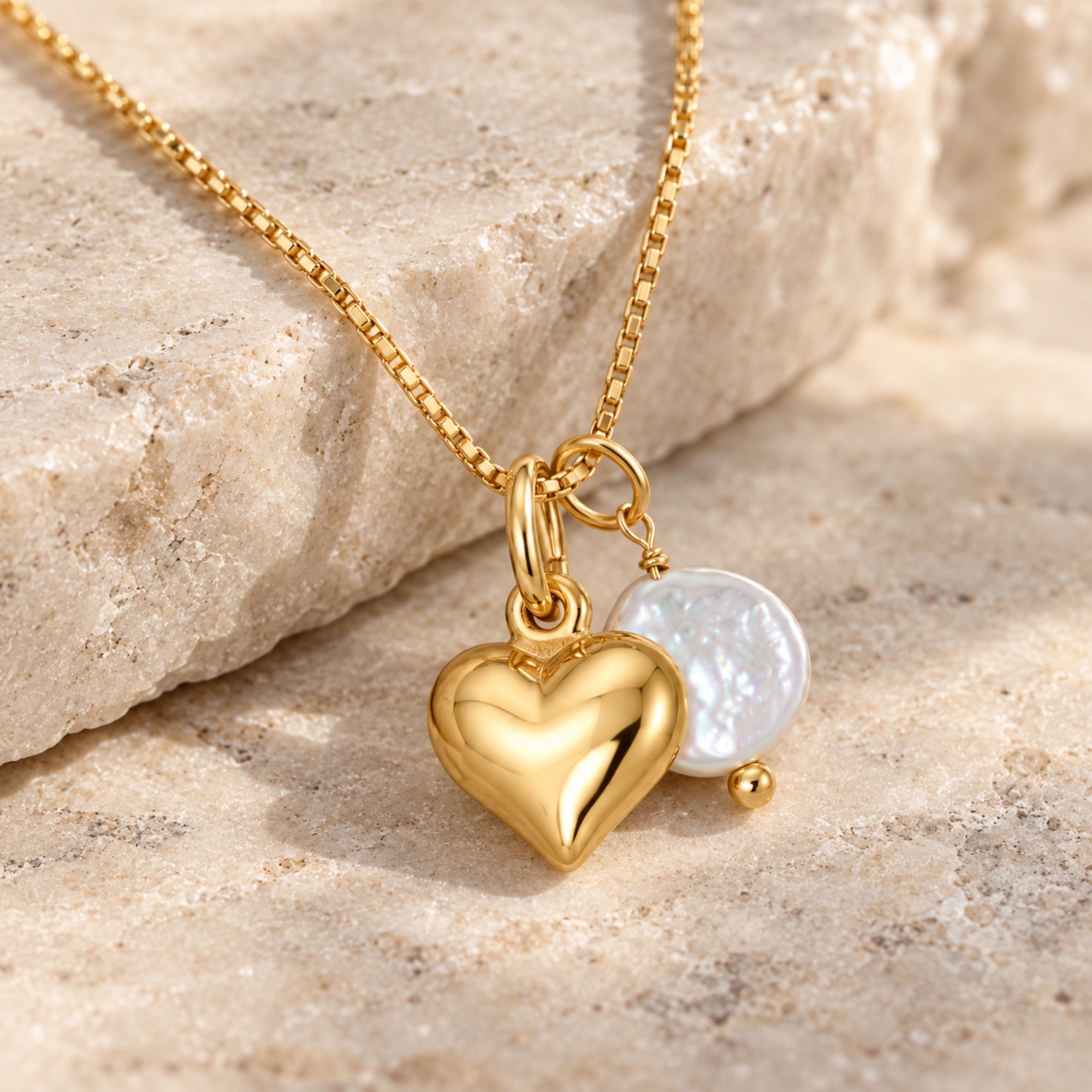 Gold-tone puffy heart necklace with a white cultured freshwater coin pearl on a fine box chain.